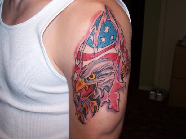 Ripped Skin Eagle With American Flag Tattoo On Man Left Shoulder